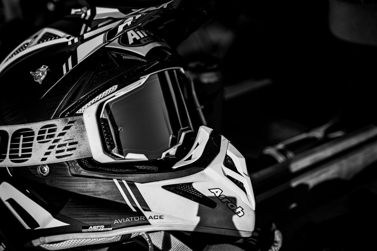 High contrast black and white close-up of a motorcycle helmet with goggles.